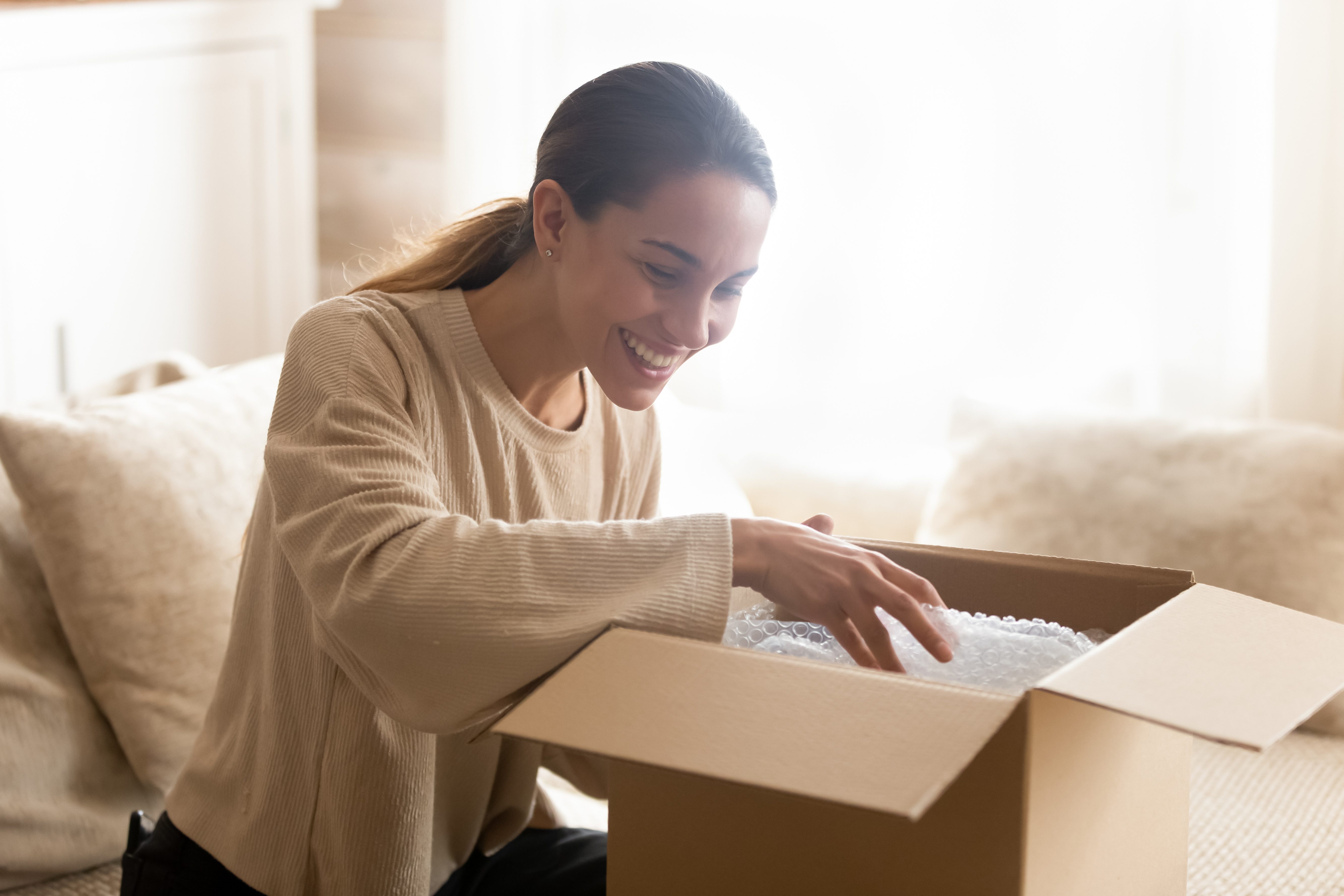 femme ouvrant un paquet contenant du bubble wrap