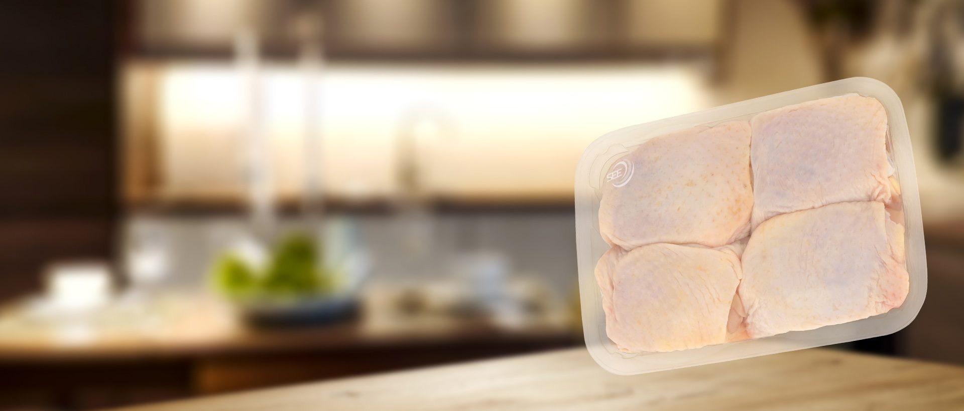 Film envolvente SES de la marca CRYOVAC para muslos de pollo en una bandeja transparente